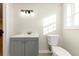 Bathroom with a gray vanity, white sink, toilet and modern lighting fixture at 2480 Miriam Ln, Decatur, GA 30032
