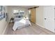 Bright bedroom featuring hardwood floors, an area rug, and stylish sliding barn door to the ensuite bathroom at 2480 Miriam Ln, Decatur, GA 30032
