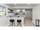 Modern kitchen with granite countertops, bar seating, wooden floors, and white cabinetry at 2480 Miriam Ln, Decatur, GA 30032