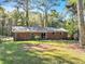 This home has a large brick patio and backyard, surrounded by lush trees at 4639 Tell Sw Rd, Atlanta, GA 30331