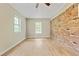 This bedroom has wood-look floors, bright windows, and a brick accent wall at 4639 Tell Sw Rd, Atlanta, GA 30331