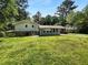 View of backyard showing the sunny lawn and trees at 6389 Cumberland Dr, Rex, GA 30273