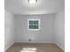 Empty bedroom with plush carpet, a window, and a closet for storage at 6389 Cumberland Dr, Rex, GA 30273