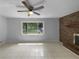 Bright living room featuring a brick fireplace, ceiling fan, and large windows at 6389 Cumberland Dr, Rex, GA 30273