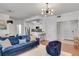 Open-concept living area flowing into the kitchen, with a comfortable blue sofa and modern bar stools at 800 Peachtree Ne St # 101, Atlanta, GA 30308
