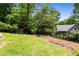 Backyard view with green grass, trees and house in the background at 1327 Harvard Ne Rd, Atlanta, GA 30306