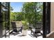 Cozy outdoor balcony with black Adirondack chairs, lush greenery and tree views at 1327 Harvard Ne Rd, Atlanta, GA 30306
