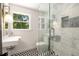 Modern bathroom features striking black and white checkered floors and a glass shower with tiled walls at 1327 Harvard Ne Rd, Atlanta, GA 30306