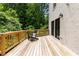 Outdoor deck with black lounge chair, painted brick siding, and view of lush greenery, perfect for relaxing and entertaining at 1327 Harvard Ne Rd, Atlanta, GA 30306