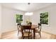 Cozy dining room featuring hardwood floors, a round table, and large windows with leafy views at 1327 Harvard Ne Rd, Atlanta, GA 30306