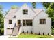 Beautiful, bright home boasts white brick, green yard, and stately staircase leading to the front door at 1327 Harvard Ne Rd, Atlanta, GA 30306