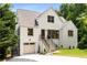 Charming white brick home featuring a well-manicured lawn, attached garage, and inviting staircase leading to the front door at 1327 Harvard Ne Rd, Atlanta, GA 30306