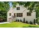 Beautifully landscaped two-story home with white painted brick, inviting front porch, and lush greenery at 1327 Harvard Ne Rd, Atlanta, GA 30306