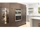 Modern kitchen with integrated appliances, quartz counters, and glass cabinet for display at 1327 Harvard Ne Rd, Atlanta, GA 30306