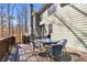 Outdoor back deck featuring a dining table, seating, and a view of the wooded backyard at 1604 Summersweet Ln, Dacula, GA 30019