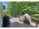 Spacious wooden deck showcasing outdoor grills and partially covered furniture at 1604 Summersweet Ln, Dacula, GA 30019
