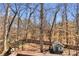 Wooded backyard featuring a play set, a storage shed, and privacy fencing at 1604 Summersweet Ln, Dacula, GA 30019