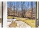 View of the wooded backyard, patio, and stepping stone path at 1604 Summersweet Ln, Dacula, GA 30019