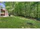Expansive backyard with a playhouse and access to a deck overlooking a lush landscape at 1604 Summersweet Ln, Dacula, GA 30019