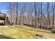 Wooded backyard featuring a small playhouse, swing set, and lots of trees at 1604 Summersweet Ln, Dacula, GA 30019
