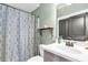 Bathroom featuring a shower with a stylish patterned curtain and vanity with cabinet storage at 1604 Summersweet Ln, Dacula, GA 30019