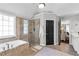 Bright bathroom featuring a soaking tub, glass shower, and modern fixtures at 1604 Summersweet Ln, Dacula, GA 30019
