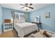 Comfortable bedroom featuring blue walls, a ceiling fan, and a plush armchair at 1604 Summersweet Ln, Dacula, GA 30019