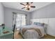 Cozy bedroom with a ceiling fan, large window, and comfortable bed and workspace at 1604 Summersweet Ln, Dacula, GA 30019