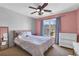 Cozy bedroom with pink accent wall, natural light, ceiling fan, and ample space at 1604 Summersweet Ln, Dacula, GA 30019