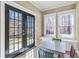 Cozy breakfast nook features light-filled windows and a table with colorful chairs next to large glass doors at 1604 Summersweet Ln, Dacula, GA 30019