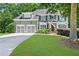 Charming two-story home featuring a manicured lawn, attached garage, and traditional architectural details at 1604 Summersweet Ln, Dacula, GA 30019