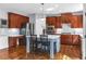Modern kitchen with island, hardwood floors, stainless steel appliances, and ample cabinet space at 1604 Summersweet Ln, Dacula, GA 30019