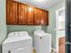 Functional laundry room with side-by-side washer and dryer with storage above at 1604 Summersweet Ln, Dacula, GA 30019