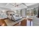 Spacious primary suite boasting hardwood floors, tray ceiling, sofa, and large windows at 1604 Summersweet Ln, Dacula, GA 30019