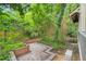Private backyard with brick patio, lush greenery, and wooded backdrop at 228 Clarion Ave, Decatur, GA 30030