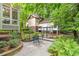 Inviting backyard patio with outdoor seating, a greenhouse, and well-manicured greenery at 228 Clarion Ave, Decatur, GA 30030