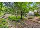 Secluded backyard with mature trees, a tranquil stream, and a lovely greenhouse at 228 Clarion Ave, Decatur, GA 30030
