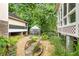 Beautiful backyard featuring a greenhouse, stone pathway, and manicured landscaping at 228 Clarion Ave, Decatur, GA 30030