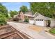 Charming brick home with a detached garage and a paved driveway surrounded by lush greenery and mature trees at 228 Clarion Ave, Decatur, GA 30030