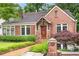 Charming brick home featuring a well-manicured lawn and a brick walkway leading to the front door at 228 Clarion Ave, Decatur, GA 30030