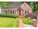 Charming brick home featuring a well-manicured lawn and a brick walkway leading to the front door at 228 Clarion Ave, Decatur, GA 30030