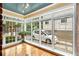 Bright sunroom featuring a wood floor, many windows, and potted plants throughout at 228 Clarion Ave, Decatur, GA 30030
