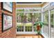 Sunny room showcasing hanging plants, brick accent wall, and expansive window views at 228 Clarion Ave, Decatur, GA 30030