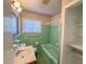Retro bathroom with a green tiled bathtub and vintage fixtures at 3082 Dove Way, Decatur, GA 30033