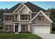 Charming two-story home featuring a mix of brick and stone, complemented by dark shutters and a well-manicured lawn at 3910 Near Star Ln, Cumming, GA 30028