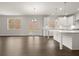 Open-concept kitchen featuring white cabinets, a center island, and seamless flow into the living area, ideal for modern living at 3910 Near Star Ln, Cumming, GA 30028