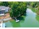 Aerial view of lakefront property with private dock, pool, and meticulously landscaped backyard at 1130 S Rudder Rd, Cumming, GA 30041