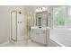 Bathroom showcases a glass-enclosed shower, white vanity, and a garden tub by a bright shuttered window at 1130 S Rudder Rd, Cumming, GA 30041