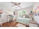 Cozy bedroom featuring hardwood floors, a daybed, a decorative desk, and a ceiling fan at 1130 S Rudder Rd, Cumming, GA 30041