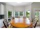 A sunlit dining area featuring a wooden table, seating, and large windows offering views of the outdoor deck at 1130 S Rudder Rd, Cumming, GA 30041